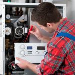 Technician checking a gas furnace with a multimeter.